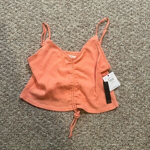 NWT. Peach colored O’Neill cropped tank with adjustable straps.
